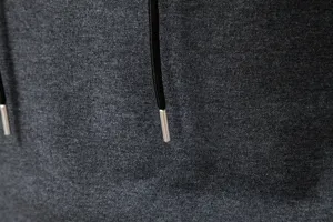 Close-up detail view of men's casual hoodie fabric texture with black drawstrings and metal tips.