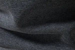Close-up fabric detail of dark grey men's casual hooded sweatshirt texture material.