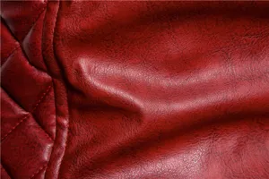 Primer plano de la textura de la chaqueta de moto de piel sintética roja con detalles.