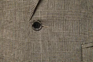 Dettaglio in primo piano della trama del tessuto in tweed a quadri e dei bottoni.