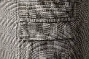 Primo piano dettagliato della tasca del blazer in lana a quadri vintage da uomo e tessuto.