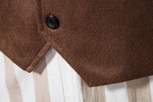 Close-up detail of brown suede vest showing textured fabric and black button craft.