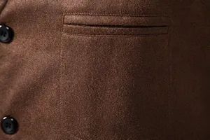 Close-up detail of brown men's suede vest fabric, pocket design and black button texture.