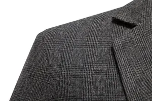 Primo piano del tessuto della giacca da uomo a quadri grigi, dettaglio spalla e revers.