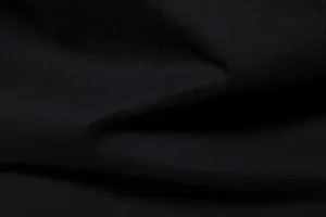 Close-up view of black cotton fabric material texture, showing fine weave and soft folds.