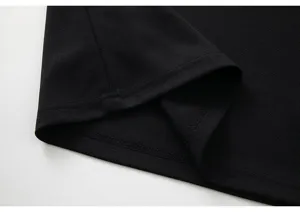 Black polo shirt hem detail, casual short sleeve t-shirt fine stitching close up display.