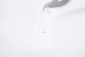 Close up of men's white polo shirt placket with buttons and fine stitching detail.
