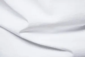 Detailed shot of white cotton t-shirt fabric, soft breathable solid color material for men.