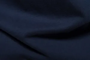 Close-up fabric texture detail shot showing fine dark blue cotton knit material quality.