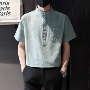 Detailed view of men's short-sleeve mandarin collar shirt in light green with front pocket.