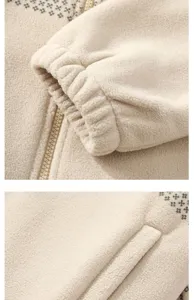 Close-up of beige fleece jacket showing zipper, elastic cuffs, and ethnic pattern details.