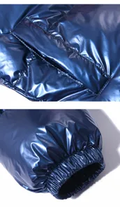 Dettaglio giacca imbottita lucida con patta tascabile funzionale e polsino elastico.