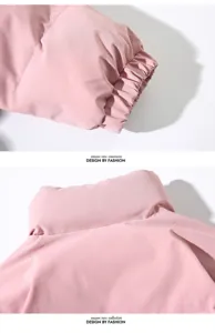 Dettaglio del piumino invernale rosa, che mostra chiaramente i polsini elastici e il collo alto.