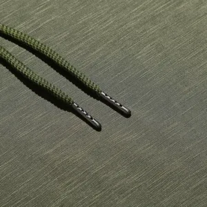 Nahaufnahme der grünen Kapuzenpullover-Kordel mit strukturierten Enden für Textildesign.