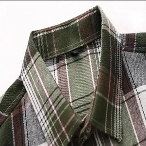 Green plaid men shirt collar detail close-up view showing neat stitching and button.