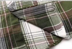 Men's green plaid short sleeve shirt fabric detail, classic tartan pattern, neat stitching.