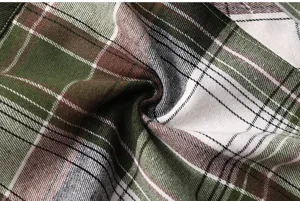 Green and brown plaid fabric detail shot, showing the soft and durable texture of the shirt.