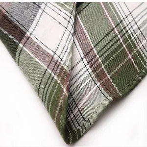 Detailed view of green and brown plaid fabric texture for men's short sleeve shirt.