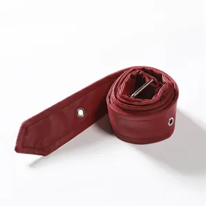 Close up shot of red leather belt strap detail featuring metal eyelets for clothing design.
