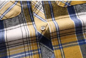 Detailed close-up view of men's short sleeve plaid work shirt fabric, texture and buttons.
