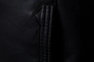 Gros plan détaillé du tissu de la veste en cuir noir avec coutures fines et belle texture.
