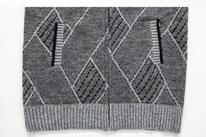 Gros plan detaille du gilet en tricot pour homme, motif argyle noir et gris avec bord côte.