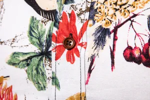 Close-up of men's linen casual shirt detail featuring floral botanical print and button.