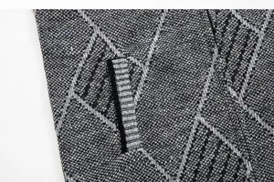 Gros plan detaille du tissu du gilet en tricot pour homme avec motif geometrique.