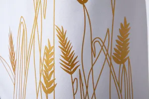 Primo piano di elegante stampa di spighe di grano dorate su tessuto bianco, fine.