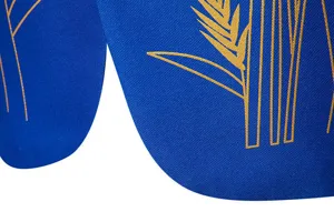 Dettaglio in primo piano della giacca da uomo blu royal con elegante motivo a grano dorato.