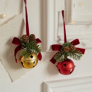 Elegant Christmas bell ornaments with red velvet bows and pine cones for festive decor.