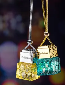 Close-up detail of elegant gold and silver hanging car perfume bottles with textured glass
