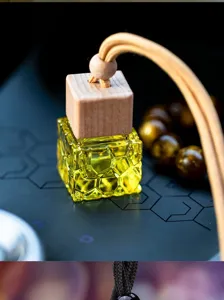 Clear yellow water cube car aromatherapy bottle with wooden cap and hanging rope.