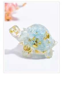 Detailed view of a handmade resin turtle figurine with blue crystals and gold foil flakes.