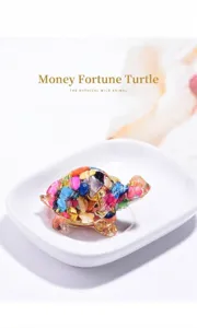 Close-up of colorful crystal chip resin turtle figurine on a white plate