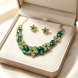 Close-up of green crystal necklace and earrings set displayed in a premium jewelry box.