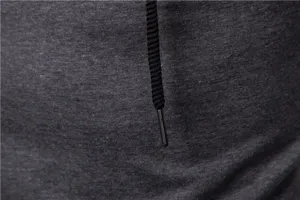 Close-up detail of dark gray hoodie fabric texture with black woven drawstring and metal tip.