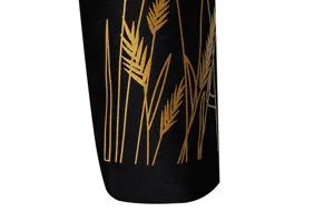 Dettaglio in primo piano della manica dell'abito da uomo con elegante stampa di grano dorato.