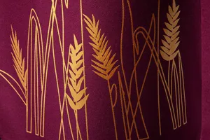 Primo piano del tessuto per abito da uomo bordeaux con bellissimi dettagli stampati in oro