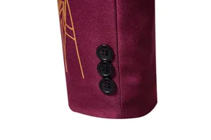 Dettaglio del polsino della giacca da uomo, tessuto bordeaux con ricamo dorato.