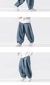 Close-up detail of the loose wide-leg denim harem pants showing fit, drape and fabric texture.