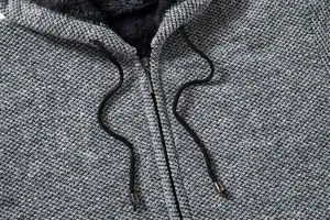 Primo piano dettaglio felpa con cappuccio maglia grigia uomo con fodera peluche e coulisse.