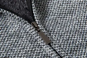 Dettaglio ravvicinato della trama del maglione in maglia da uomo e della cerniera lampo.