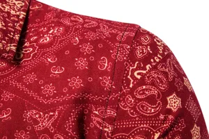 Close-up detail of red long sleeve shirt featuring traditional ethnic paisley print fabric.