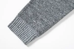 Dettaglio della manica del maglione da uomo, tessuto testurizzato grigio e polsino a coste.