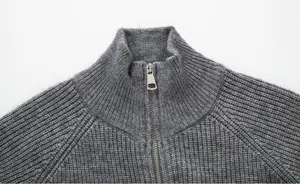 Gros plan sur le col du cardigan en tricot gris pour homme et détail de fermeture.