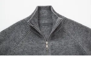 Gros plan détaillé sur la texture du pull gris à col montant et demi-zip pour homme.