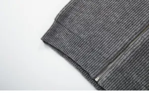 Vue détaillée de l'ourlet inférieur et de la fermeture éclair d'un gilet gris.