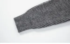 Détail de manche tricot homme gris, gros plan poignet côtelé uni pour pull décontracté.