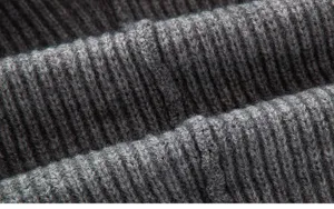 Vue rapprochée d'un tissu de pull en tricot côtelé gris foncé avec texture fine.